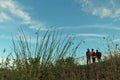 Meadow background and  blurry happy young women standing against blue sky. Friendship and travel together with best friends. Royalty Free Stock Photo