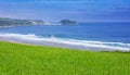 Meadow and beach in the city of Zarautz, with the island San AntÃÂ³n Raton de Getaria in the background Royalty Free Stock Photo