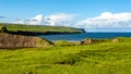 Meadow with green grass next to Doolin bay with the cliff in the background Royalty Free Stock Photo