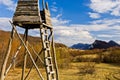 Meadow with hunting watchtower with mountain peaks in background, Homolje mountains landscape on a sunny day in early spring