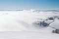 A meadow on the top of a mountain surrounded by fog on a sunny day Royalty Free Stock Photo