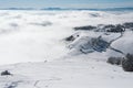 A meadow on the top of a mountain surrounded by fog on a sunny day Royalty Free Stock Photo