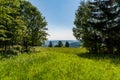 Meadow with trees and lower hills on the background near Nova Ves village in Jeseniky mountains in Czech republic