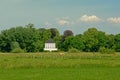 Meadows in the flemish countryside with a fancy mansion in beween trees ehind