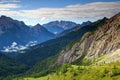 Meadows and jagged peaks of Carnic Alps and Dolomiti Pesarine Royalty Free Stock Photo