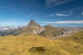 Meadows with mountains around and the Midi d`Ossau peak in the Pyrenees on a clear day with some small cloud