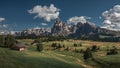 Meadows with wooden cabins at Alpe di Siusi during summer with view to mountains of Plattkofel and Langkofel in the Dolomite Alps Royalty Free Stock Photo