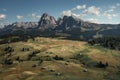 Meadows with wooden cabins at Alpe di Siusi during summer with view to mountains of Plattkofel and Langkofel in the Dolomite Alps Royalty Free Stock Photo