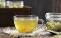 Meadowsweet floral herbal tea in glass cup on vintage books with dried herb in a jar nearby on the wooden rustic table Royalty Free Stock Photo