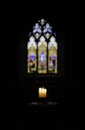 The Meager light of a Church Candle in dark a Church Royalty Free Stock Photo