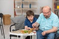 A father and son are sitting on the sofa sharing slices of pizza. Royalty Free Stock Photo