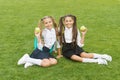 Meal break can be fun. Happy kids hold apples on green grass. Little girls enjoy school break outdoors. Healthy eating