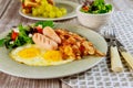 Meal for breakfast egg, sausage, bacon, salad with fork and knife Royalty Free Stock Photo