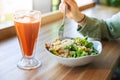 Meal of classic caesar salad with fresh carrot juice