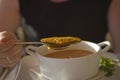 Meal fish soup in a white bowl with a spoon of mussel eaten by men