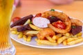 Meal for the Munich Oktoberfest with sausages, potato, cabbage and pretzels served with beer over stone backround. Selective focus Royalty Free Stock Photo