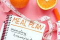 Meal plan for weight loss with orange on pink surface Royalty Free Stock Photo