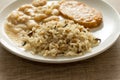 Pork chop, Brown rice and white beans. White dish on wooden table. Detail of food dish, closeup, selective focus.