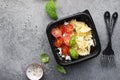 Meal prep. Black lunch boxes. Pasta bows, cherry tomatoes, young cheese, salt, pepper, basil. On a dark background Top Royalty Free Stock Photo