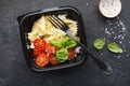 Meal prep. Black lunch boxes. Pasta bows, cherry tomatoes, young cheese, salt, pepper, basil. On a dark background Top Royalty Free Stock Photo