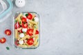 Meal prep containers with pasta salad, tomatoes, mozzarella cheese, red onion and basil Royalty Free Stock Photo