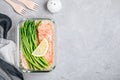 Meal prep lunch box container with baked salmon fish, rice, green asparagus