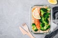 Meal prep lunch box containers with baked salmon fish, rice, green broccoli