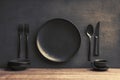 Mealtime elegance Top view of black plate with utensils