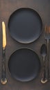 Mealtime elegance Top view of black plate with utensils