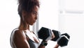 Mean muscles in the making. a young woman working out with dumbbells in a gym.