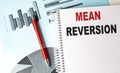 MEAN REVERSION text on notebook on chart background Royalty Free Stock Photo