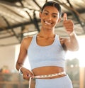 Measure, lose weight or happy woman with thumb up or tape for waist or body goals in fitness studio. Gym, thumbs up or Royalty Free Stock Photo