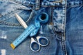 Measure tape around metal scissors on jeans fabric Royalty Free Stock Photo