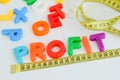 Measure your profit concept written with magnetic colored letter blocks with measuring tape