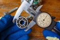 Measurement of the ball bearing outer diameter by a master in gloves with a slide caliper Royalty Free Stock Photo