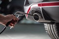 Measurement of exhaust emissions at the technical inspection station. A car repairman applies a probe to the exhaust