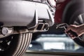 Measurement of exhaust emissions at the technical inspection station. A car repairman applies a probe to the exhaust