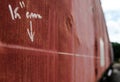 Measurement values shown in a shallow focus, written by hand on the side of an old, weathered railway carriage. Royalty Free Stock Photo