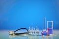 Measuring beaker, medical flask with purple chemical reagent. Six ampoules with liquid, syringe and phonendoscope, blue