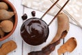 Measuring cup with tasty tamarind sauce and fresh pods on white wooden table, flat lay