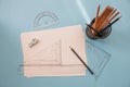 measuring and drawing tools. A sheet of white paper, pencils, rulers on the desktop.