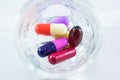 Measuring glass with capsules and tablets Royalty Free Stock Photo