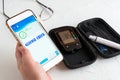 Measuring glucose levels and using smart phone. Royalty Free Stock Photo