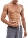 Measuring his rock hard abs. Cropped image of a muscular man measuring his torso against a white background. Royalty Free Stock Photo