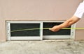 Measuring length of sliding glass window, basement, tape measure, yellow line Inspect window installation, house construction,