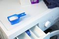 A measuring plastic container with washing powder and open container for loading washing powder in washing machine in home laundry Royalty Free Stock Photo