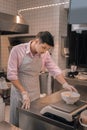 Dark-haired chef measuring salad before serving it to client