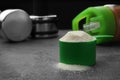 Measuring scoop of protein powder on grey stone table, closeup. Royalty Free Stock Photo