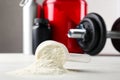 Measuring scoop of protein powder on white