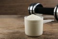 Measuring scoop of protein powder on table, closeup. Space for text Royalty Free Stock Photo